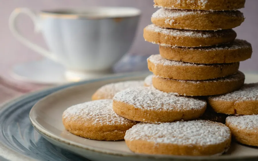 Pile de sablés dorés saupoudrés de sucre, sur une assiette de grès